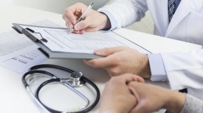 close-up-doctor-filling-medical-form-with-patient-800x445